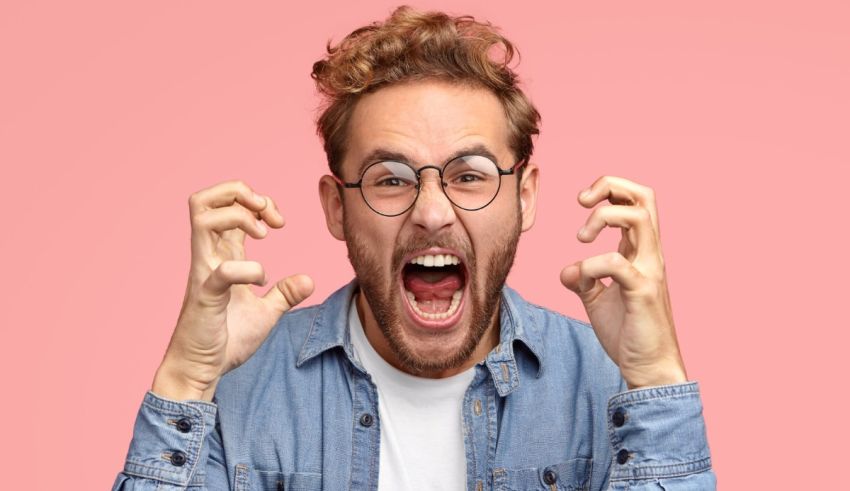 A man with glasses is making a face with his hands.