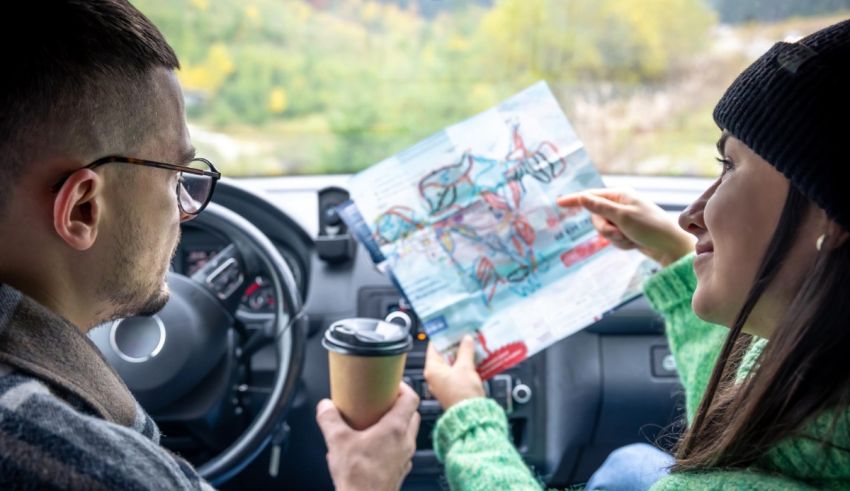 A couple looking at a map while driving in a car.