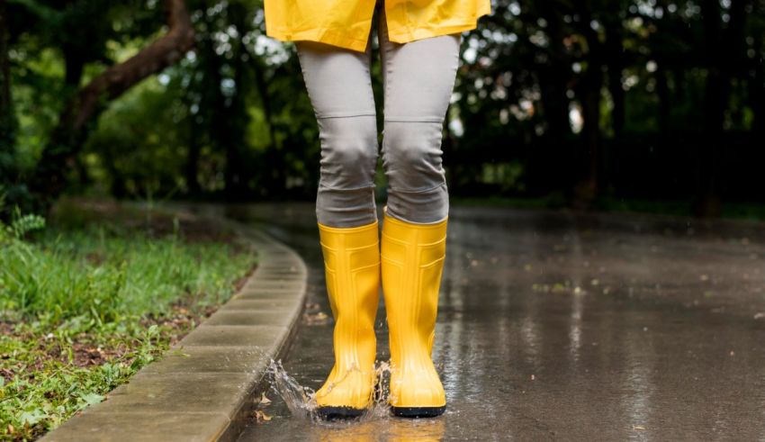 A woman in yellow rain boots standing in a puddle.