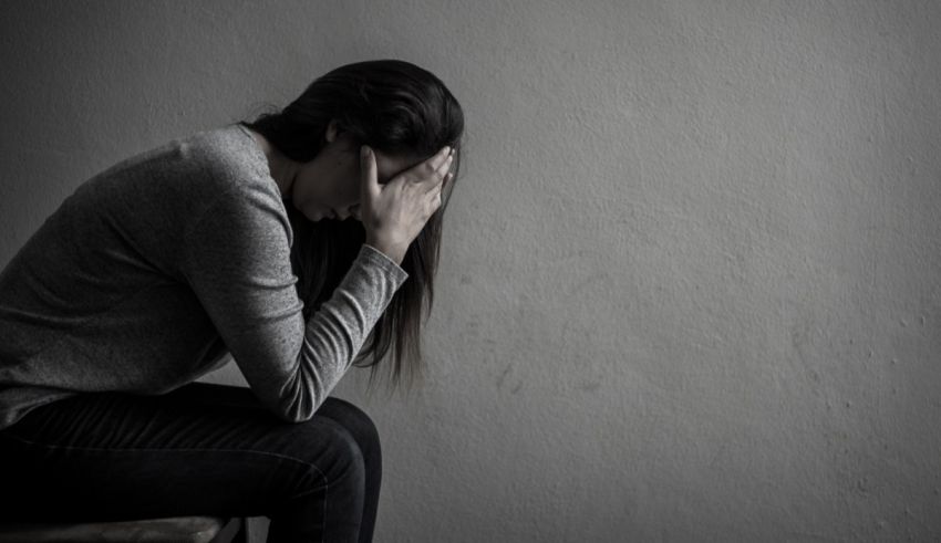 A woman sitting on a chair with her hands on her head.