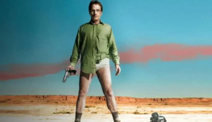 A man is standing in the desert holding a gun.