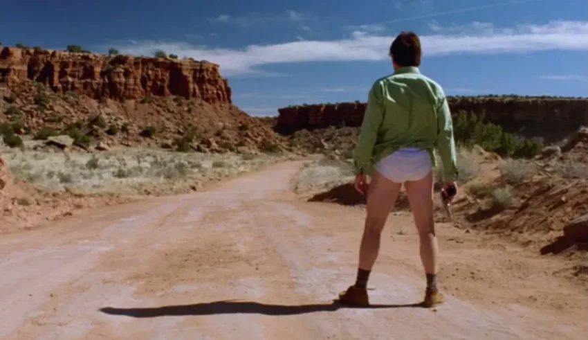 A man in shorts standing on a dirt road.