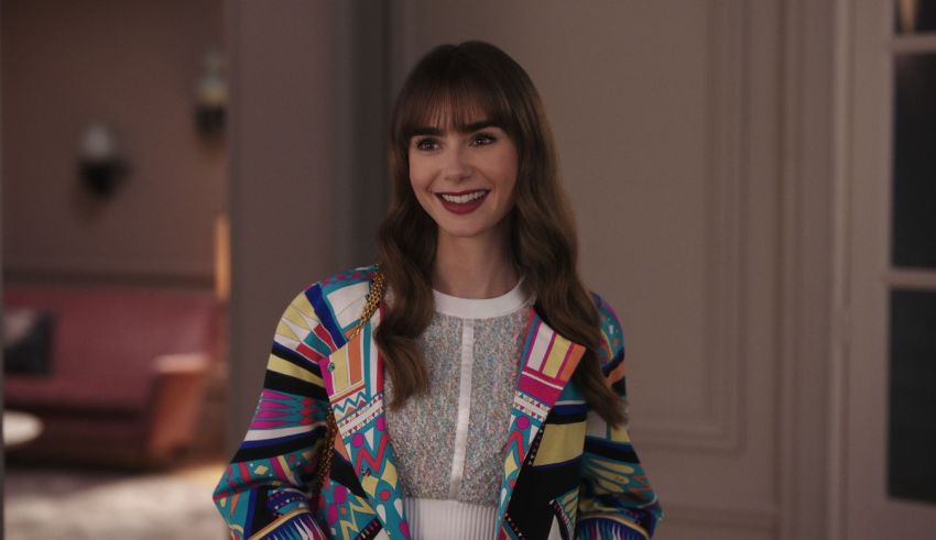 A woman in a colorful jacket standing in a room.