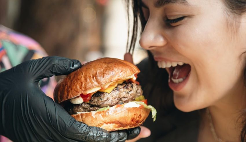 A woman is holding a burger in her hands.