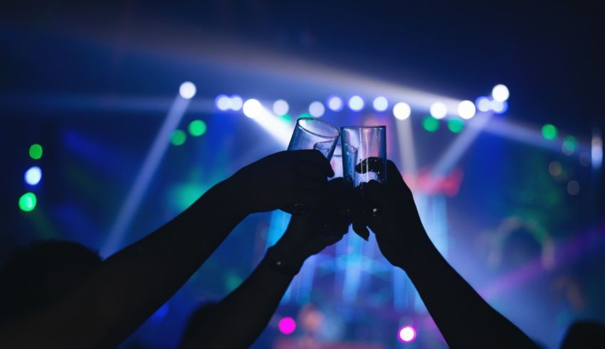 Two people toasting glasses at a concert.