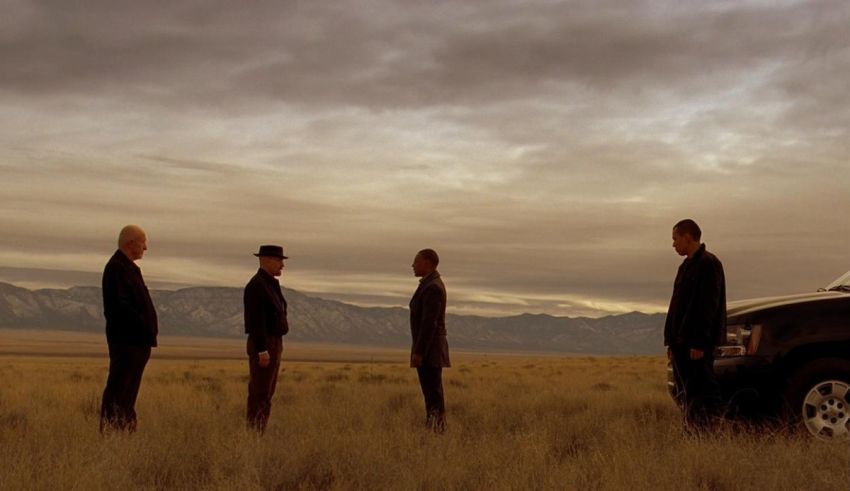 A group of men standing in a field near a truck.