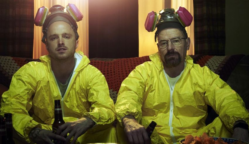 Two men in yellow suits sitting on a couch.