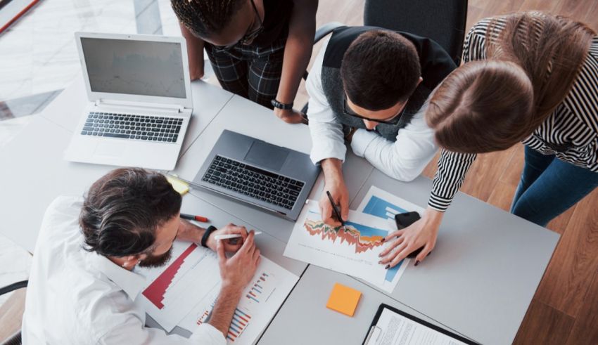 A group of people sitting around a table looking at graphs.