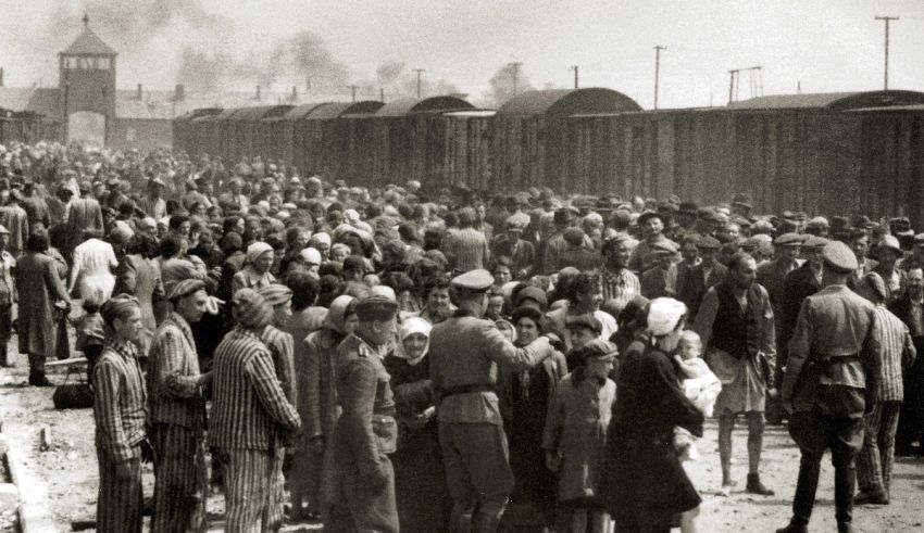 A crowd of people standing in front of a fence.