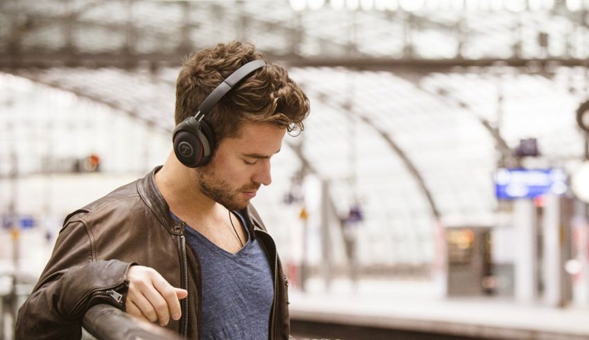 A man wearing headphones in a train station.