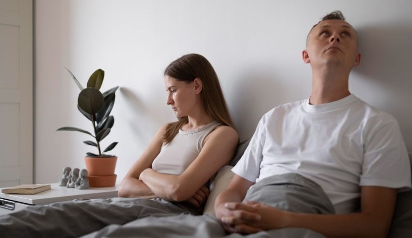 A man and woman are sitting in bed and looking at each other.