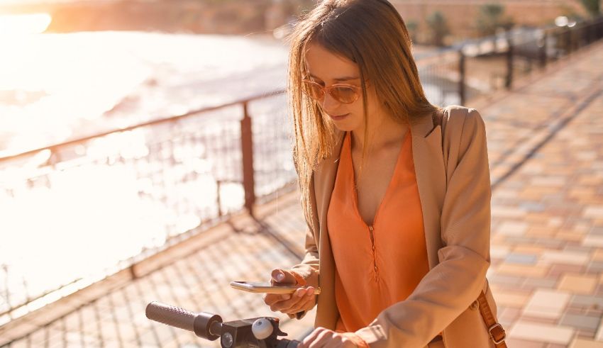 A woman on a bicycle looking at her phone.