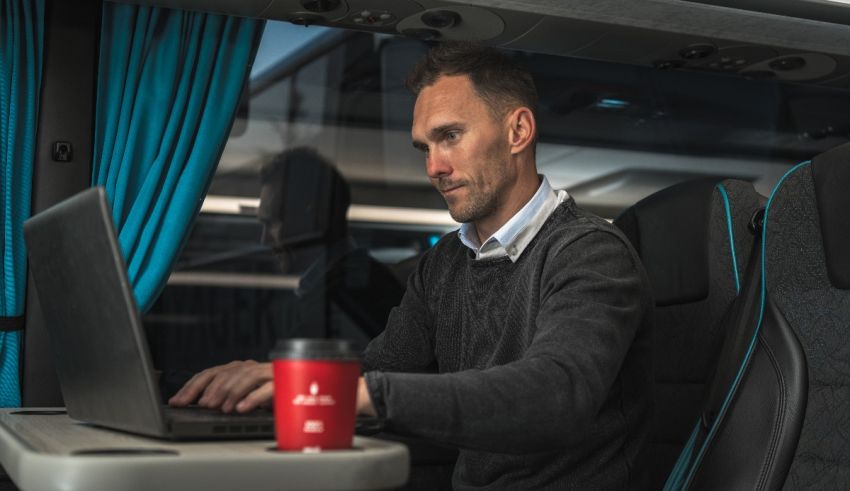 A man using a laptop on a bus.