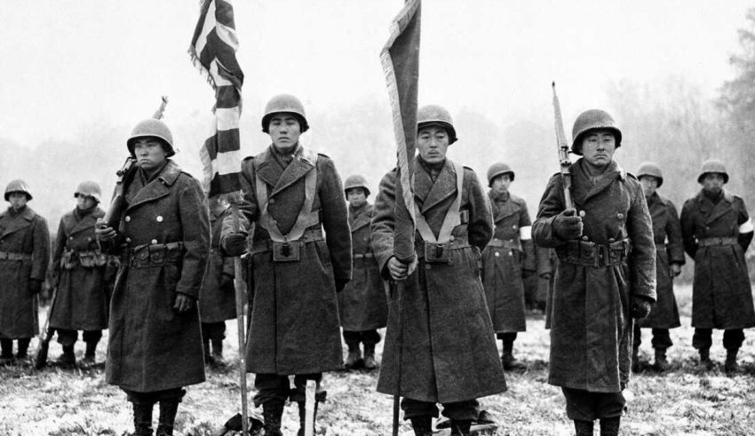 A group of soldiers standing in a field holding flags.
