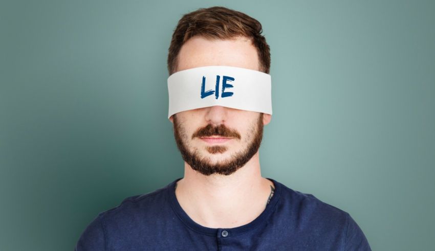 A man with a blindfold covering his eyes with the word lie.
