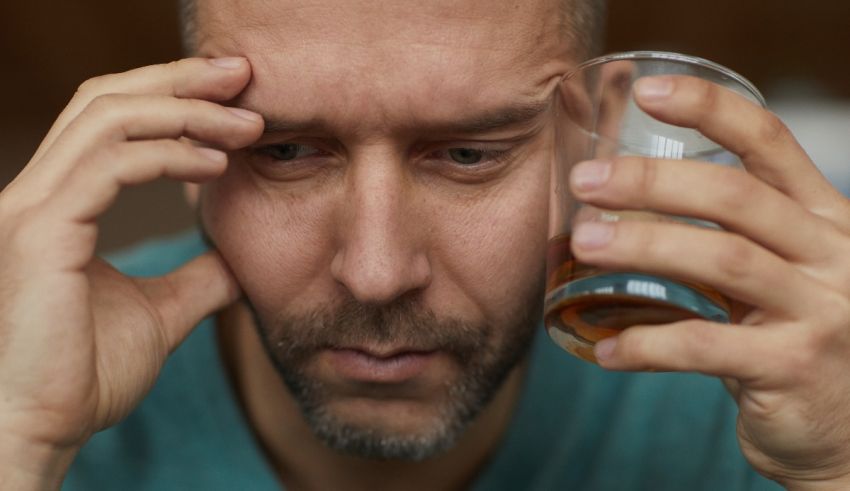 A man holding a glass of whiskey.