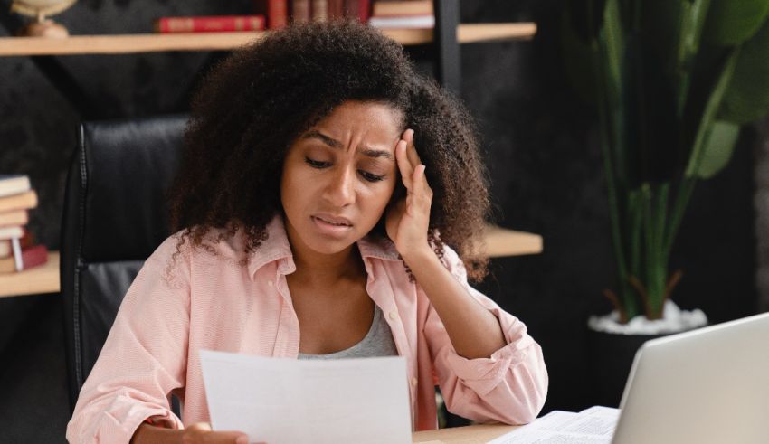 A woman is sitting at a desk with papers in front of her.