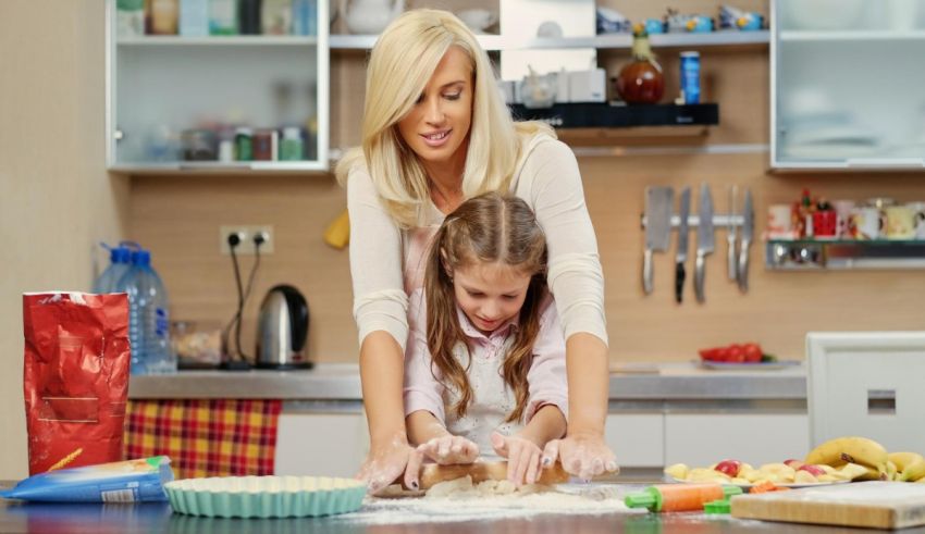 A woman and her daughter are making cookies in the kitchen.
