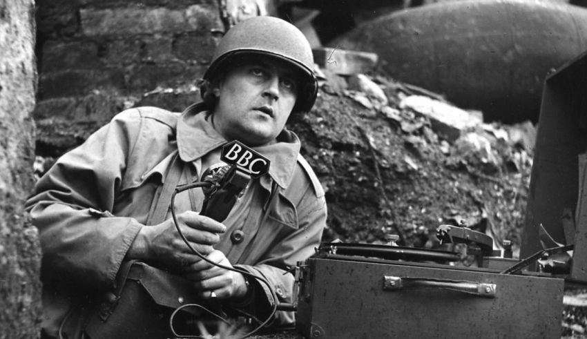 A man in a trench holding a radio.