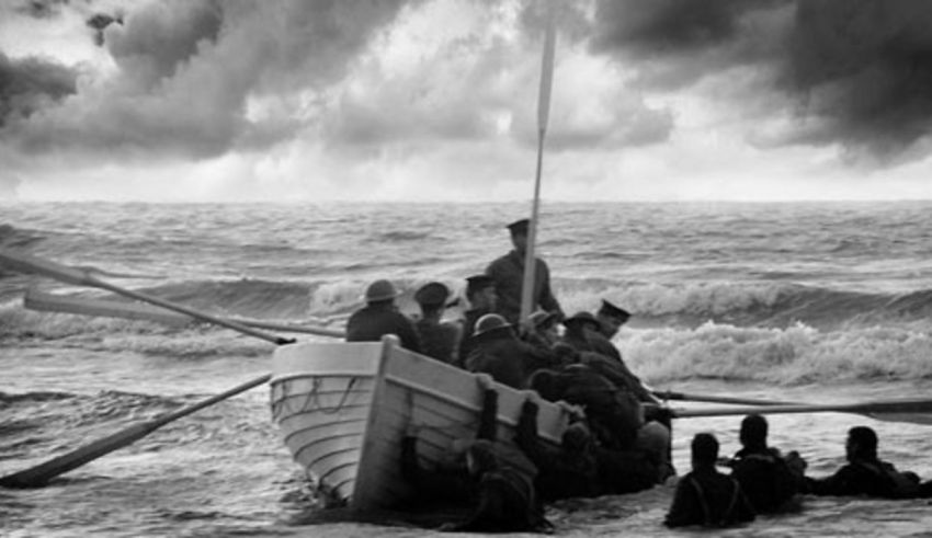 A black and white photo of people in a boat in the ocean.