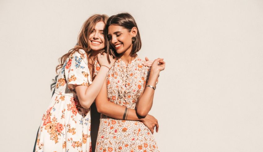 Two women in floral dresses posing for a photo.
