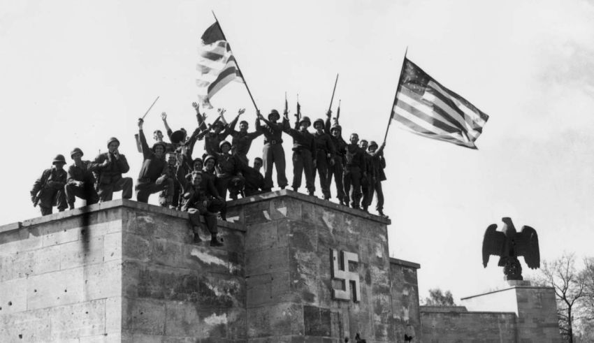 A group of men standing on top of a wall with flags.