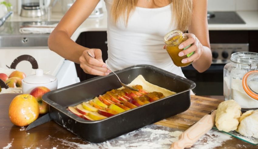 A woman is preparing a fruit tart in a pan.