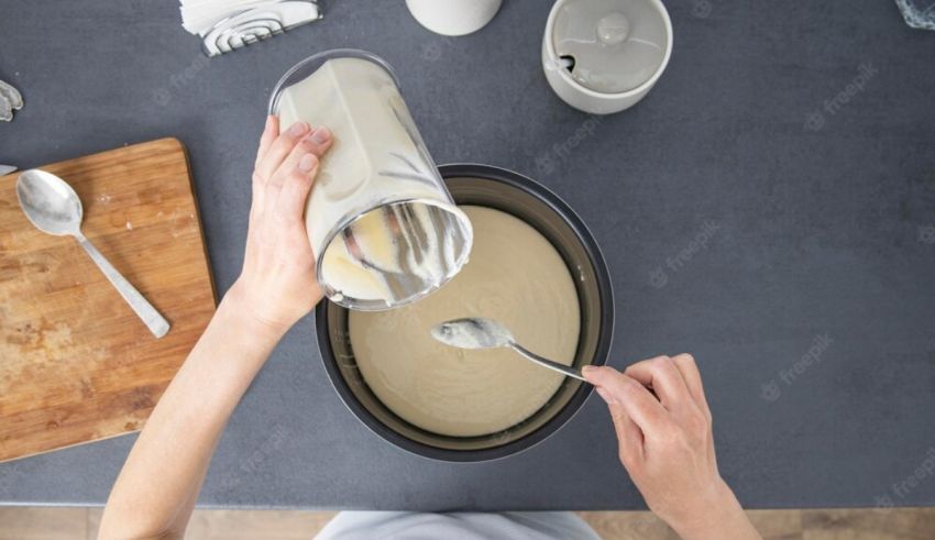 A woman pouring milk into a bowl with a spoon.