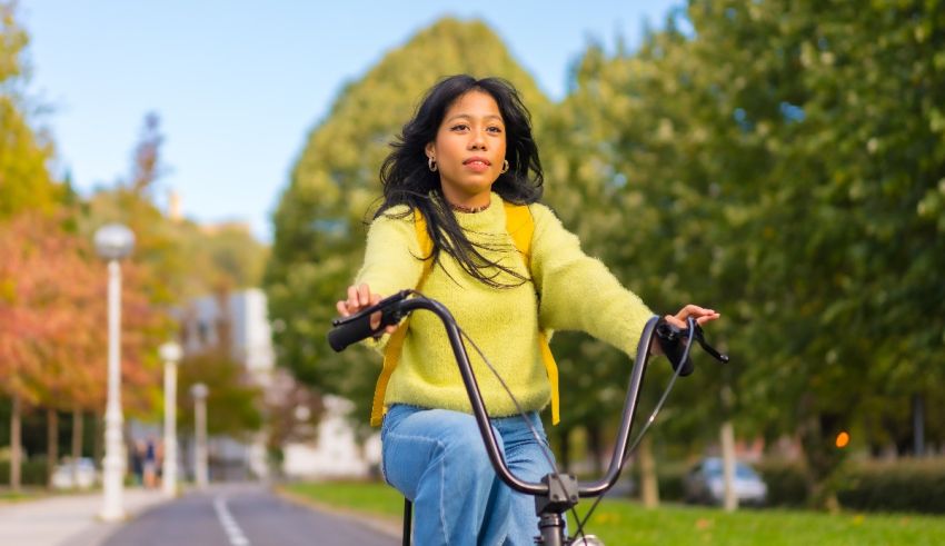A young asian woman riding a bicycle in a park.