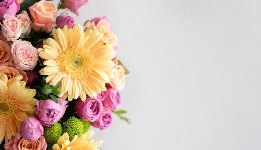 A bouquet of pink, yellow and orange flowers on a white background.