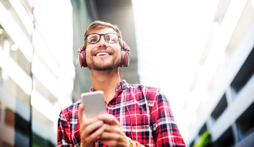 A man wearing headphones and listening to music on his phone.