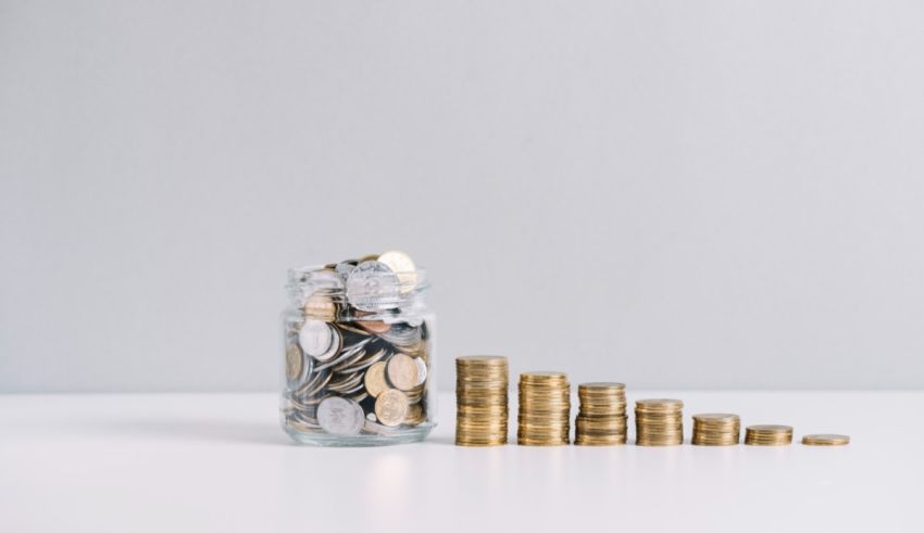 A jar full of coins on a white table.