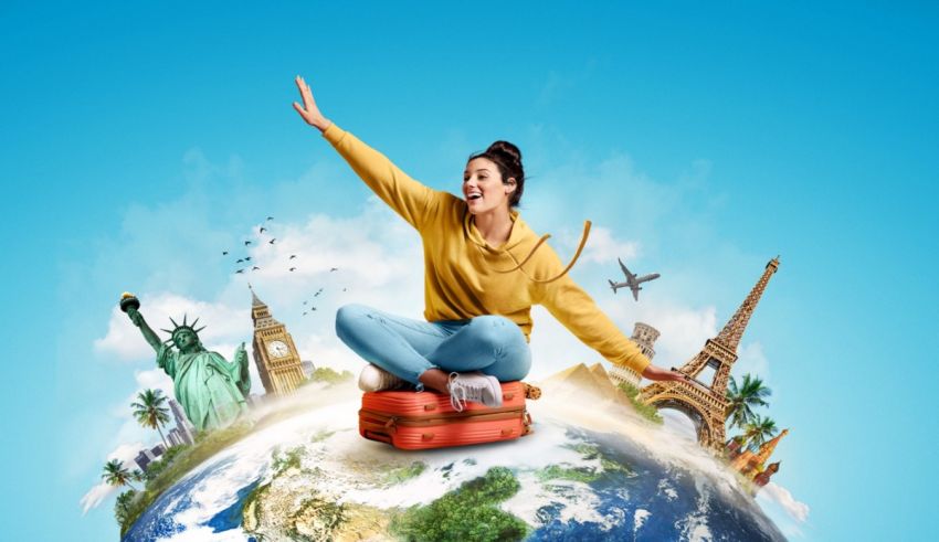 A woman is sitting on top of a globe with a suitcase.