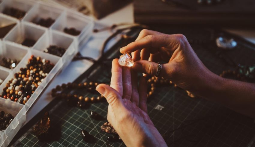 A person is putting a piece of jewelry on a table.