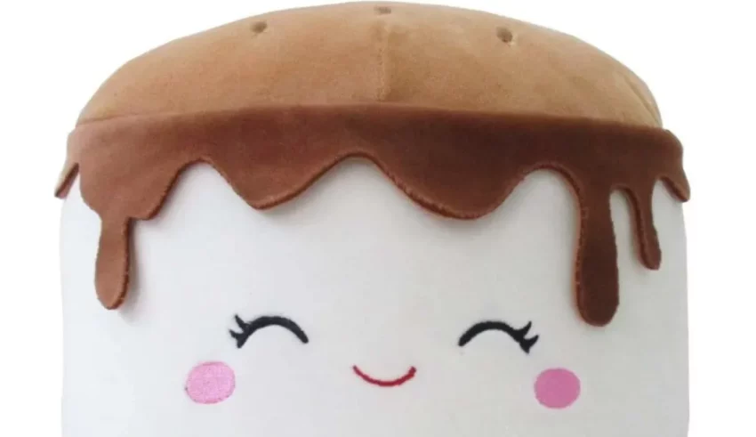A marshmallow shaped plush toy with chocolate dripping on it.