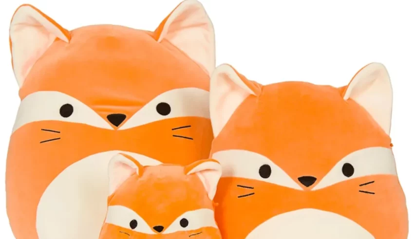 Three orange stuffed foxes sitting next to each other.