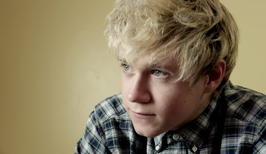 A young man with blonde hair and a plaid shirt.