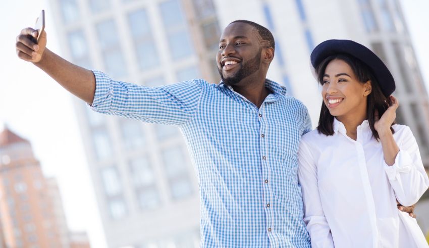Young african american couple taking a selfie in the city.