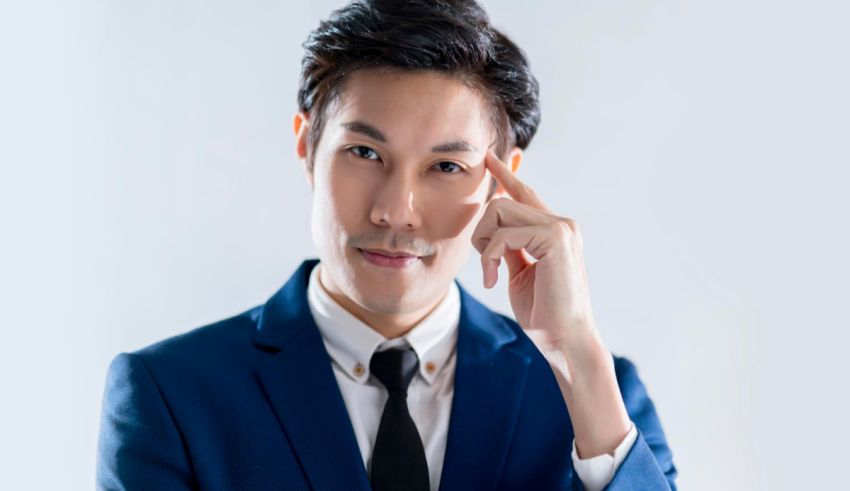 Asian businessman posing with his hand on his head.