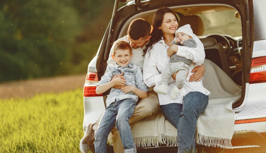 A family is sitting in the trunk of a car.