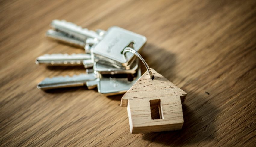 A wooden house key with keys on a wooden table.