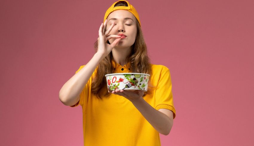 A young woman holding a bowl of ice cream on a pink background.