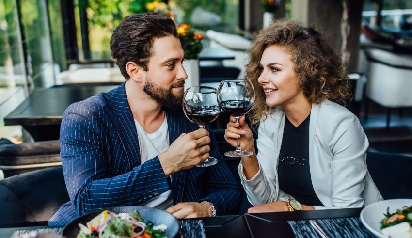 A man and woman are drinking wine at a restaurant.