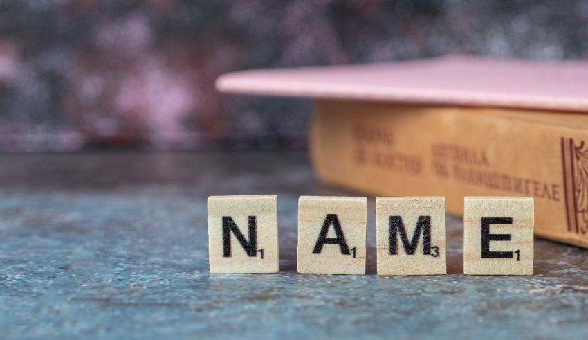 The word name spelled out in wooden blocks on top of a book.