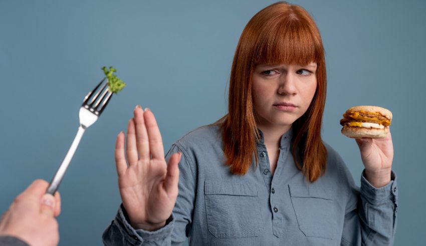 A woman is holding a fork while holding a hamburger.