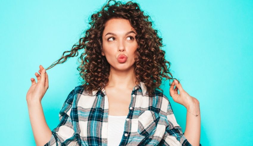 A young woman with curly hair is making a funny face.