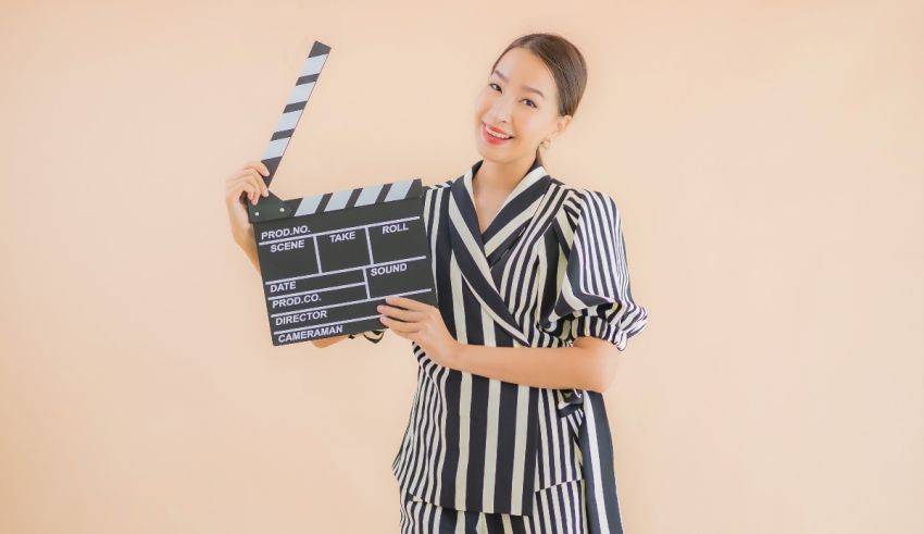 Asian woman holding a clapper board.