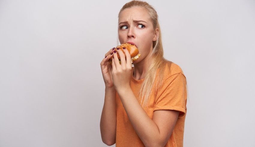 A woman is eating a hamburger on a white background.