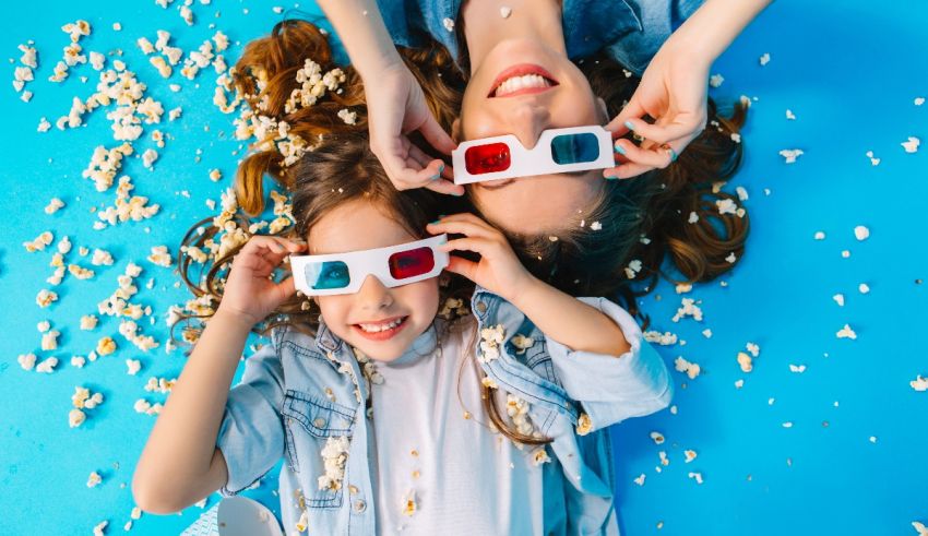 A mother and daughter wearing 3d glasses on a blue background.