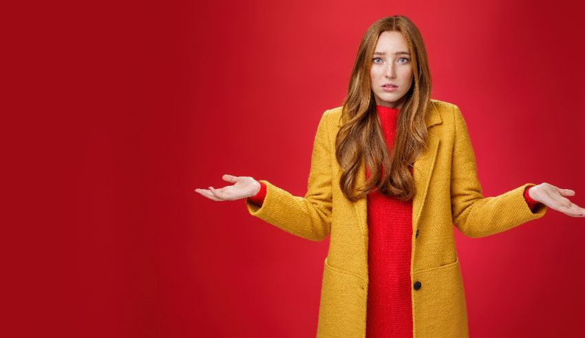 A young woman in a yellow coat standing on a red background.